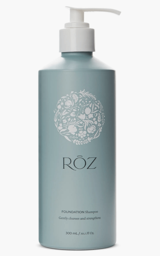 sea foam green bottle of shampoo with white pump and floral design with the brand name ROZ